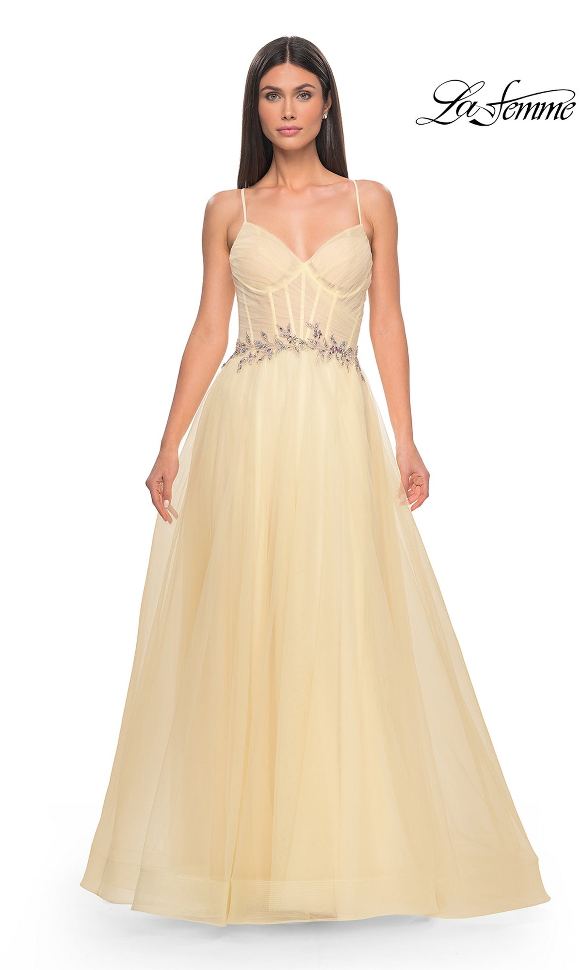 A woman wears the La Femme Sheer-Bodice Long A-Line Prom Dress 32117, featuring thin straps and floral waist embellishments, standing against a plain white background.